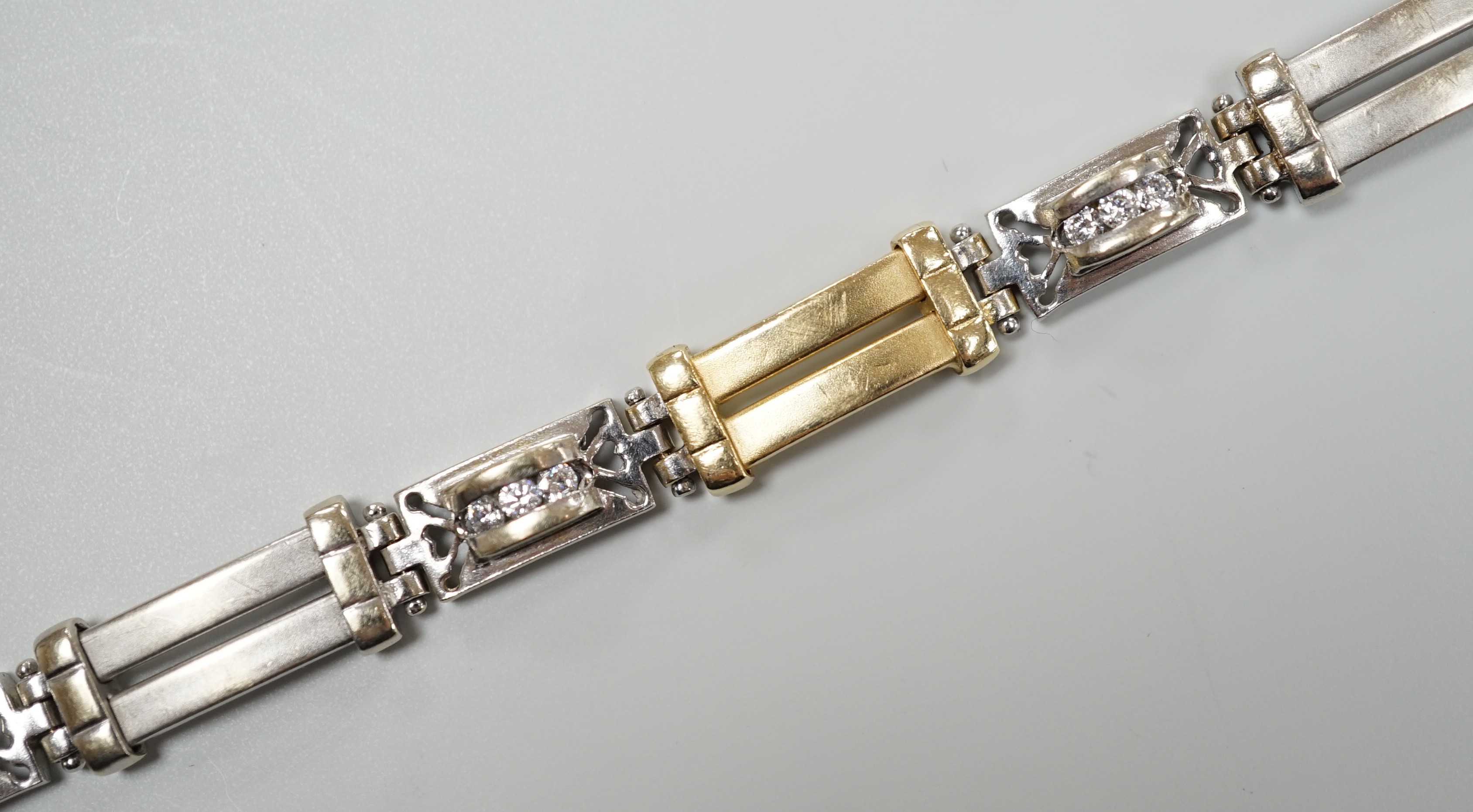 A modern two colour 585 and twelve stone diamond set bracelet, 17.75cm, gross weight 19.2 grams.